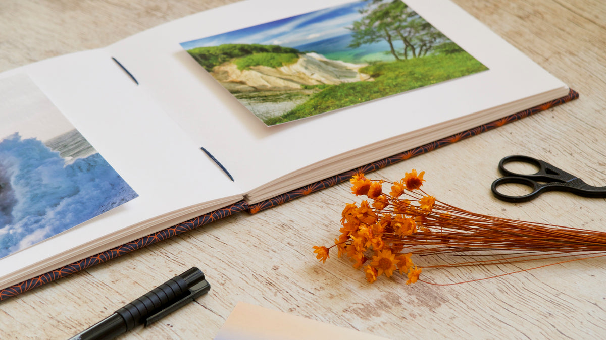 Album photos format A5 reliure copte personnalisable, ouvert bien à plat sur une table