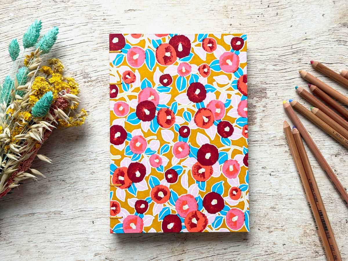 Détail du papier de croquis et de la reliure cousue main du carnet Camélias moutarde