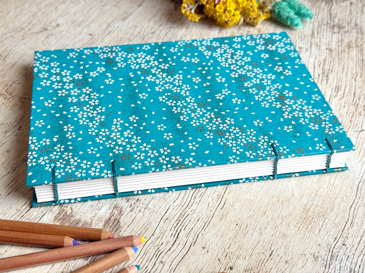Détail du papier de croquis et de la reliure cousue main du carnet Fleurs au vent bleu canard